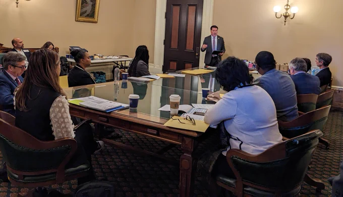 Assemblymember Grayson speaks to CDFI representatives around a table in the California State Capitol