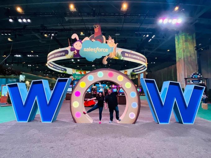 Mike Gerholdt and Lisa Dick posing in front of the "wow" activation at Salesforce World Tour Washington D.C. 