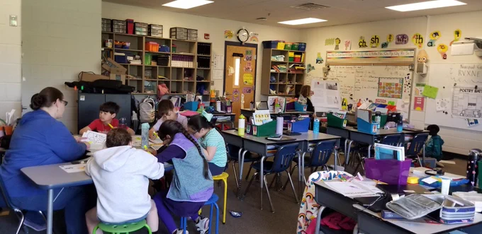 Students and teacher working at a table 