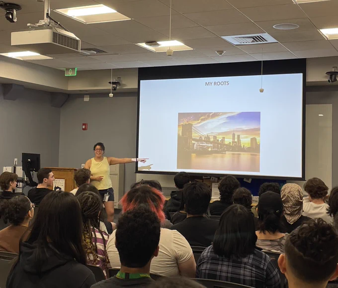 Scientist in front of classroom and presents her roots and upbringing to students
