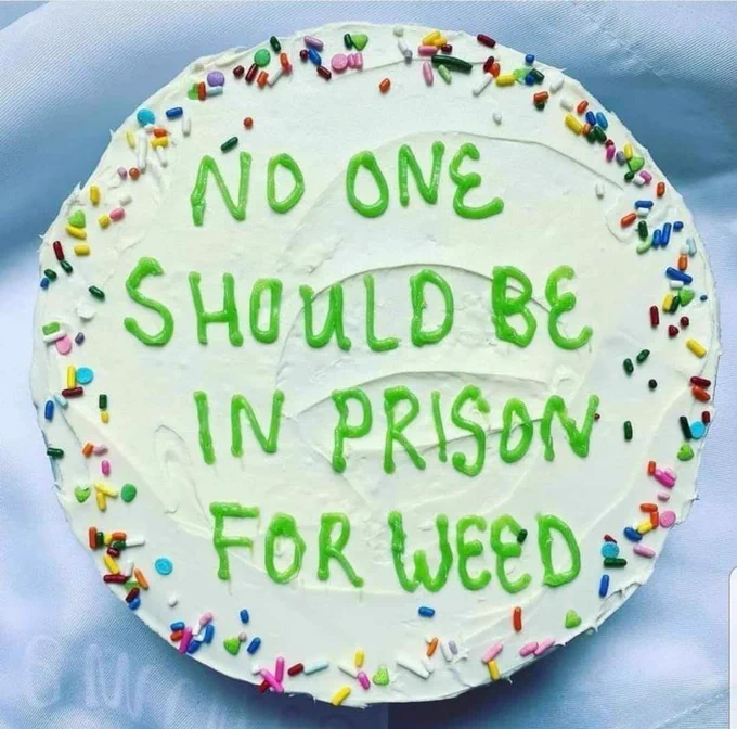 Cake with green icing letters that say "no one should be in prison for weed"