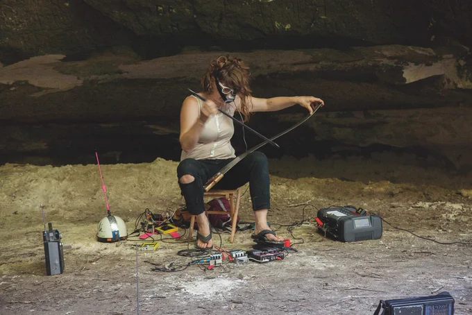 person using tools in cave-like environment