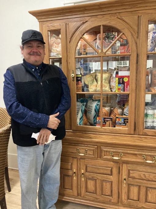 Photo: Melvin Arthur with the Be’3Einoooonesi Cebisee (Walking Cedar Tree) Food Share Cabinet in the Native American Education, Research, & Cultural Center at the University of Wyoming. Photo by Christine Porter.