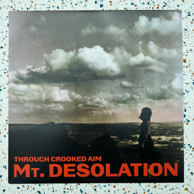 The new album from Tim and Jesse’s brilliant side-project, Mt. Desolation, which is titled “Through crooked aim” on Vinyl, sat on a table. I am so proud of my bandmates (pride not pictured), it’s a wonderful album. 💕 