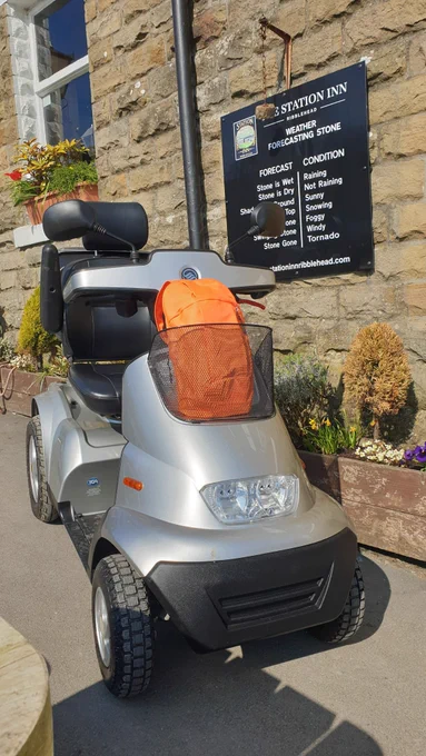 Silver mobility scooter parked outside the Station Inn at Ribblehead, Yorkshire Dales