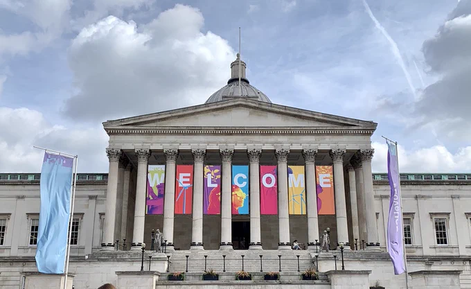 The Wilkins Building on an overcast day. There are banners that say Welcome in bright colours.