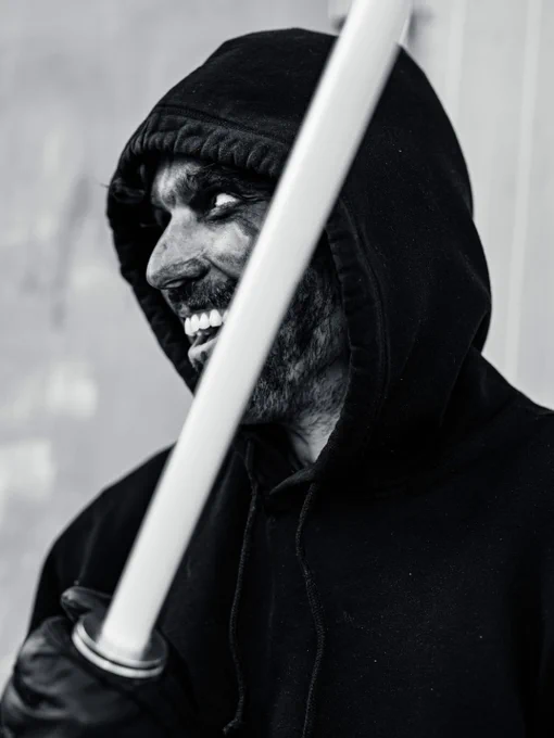 A smiling person with face paint and a laser sword