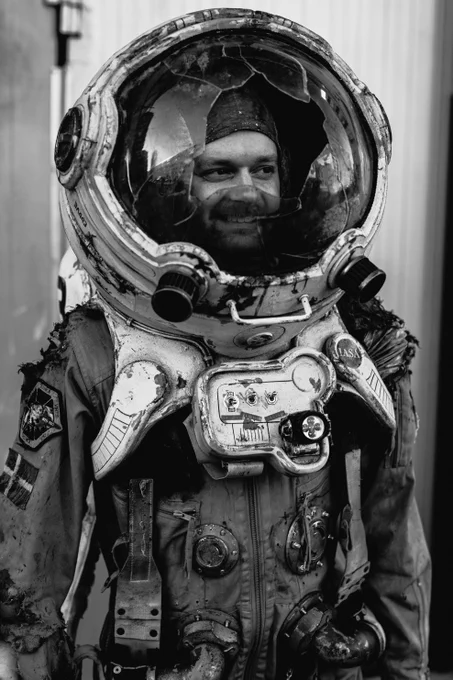 A man is looking happy wearing a trashed space suit costume