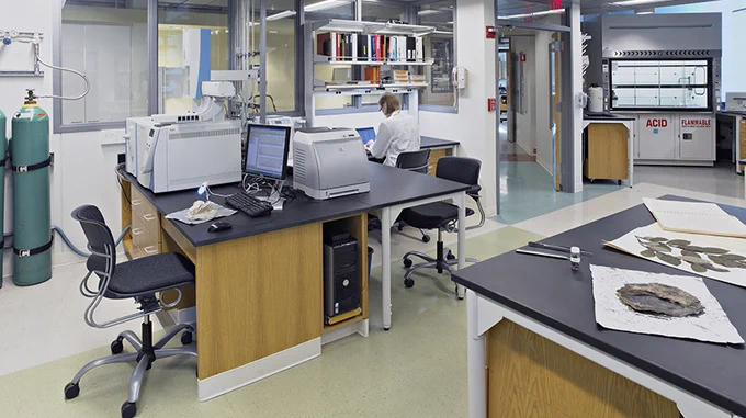 photo of a geoscience lab with analytical instruments, fume hoods, and leaf samples