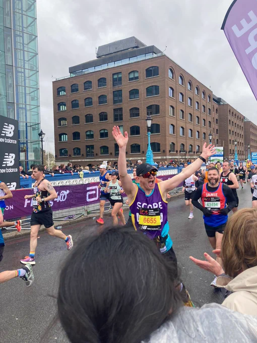 Team Scope runner with arms in the air as he passes our supporters