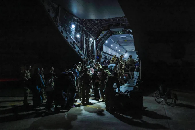 Evacuees boarding a plane at night.