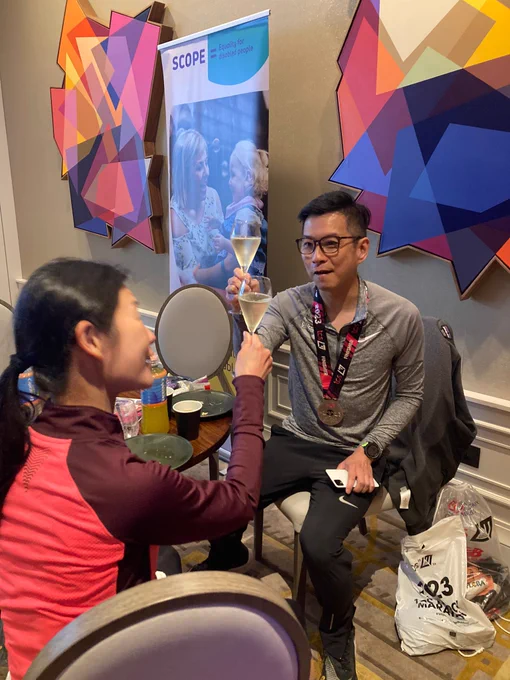 Scope runner clinking a glass of sparkling wine in celebration.