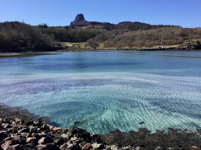 Galmisdale Bay - a beautiful blue shallow bay with the peak of An Sgurr in the background. 