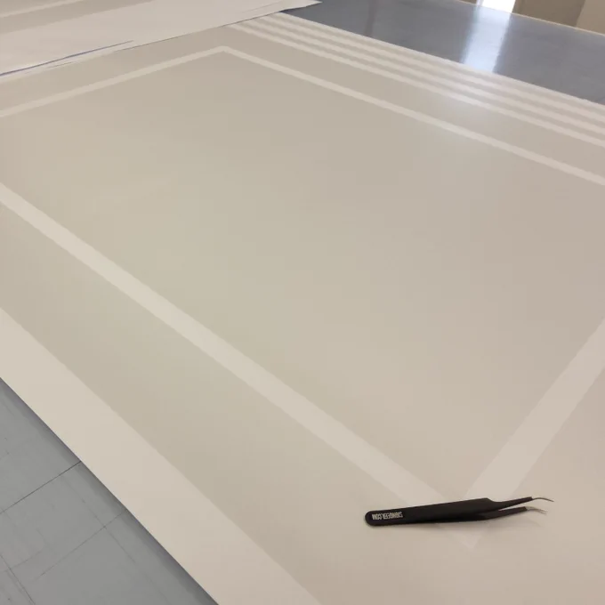 Some custom cut frosted vinyl being prepared on a workbench.