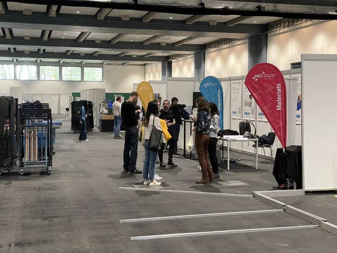 A group of people gathered in front of their demo booth discussing.