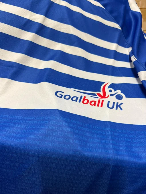 close up photo of a blue and white shirt with the Goalball UK logo on and people's names printed into the material