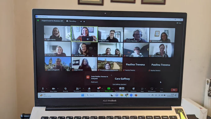 Laptop screen with zom meeting with 13 people with cameras on and four cameras turned off. 