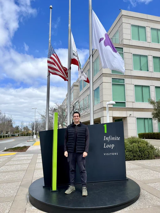 A photo of Max standing in front of IL1, a building at Infinite Loop used to signify the first year completed at Apple.