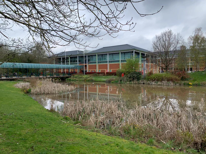 Picture of the conference centre, with a lake in the front.
