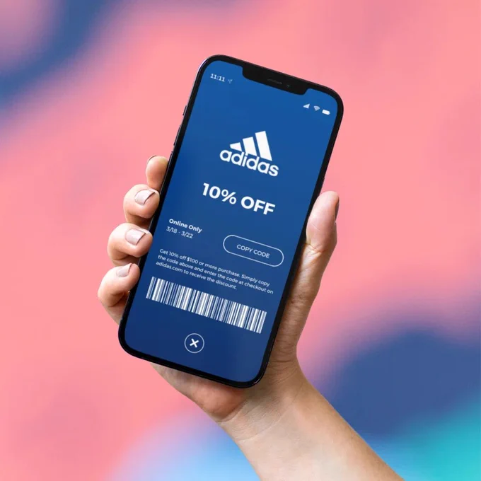 Someone holding a phone with an Adidas discount on the screen