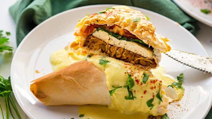 Close up shot of Benedict fillo pocket cut in half, on a white plate