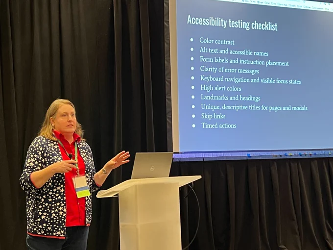 Stephanie Leary at a podium giving a presentation with slides behind her with the heading "Accessibility Testing Checklist." 