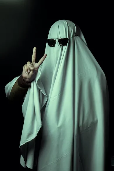 Royalty free image from Unsplash - credit in main body of the tweet. The image shows a person dressed as a ghost in a sheet and a pair of sunglasses holding up a peace sign.