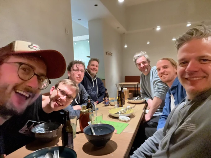 Mens sitting at a table and smiling into the camera