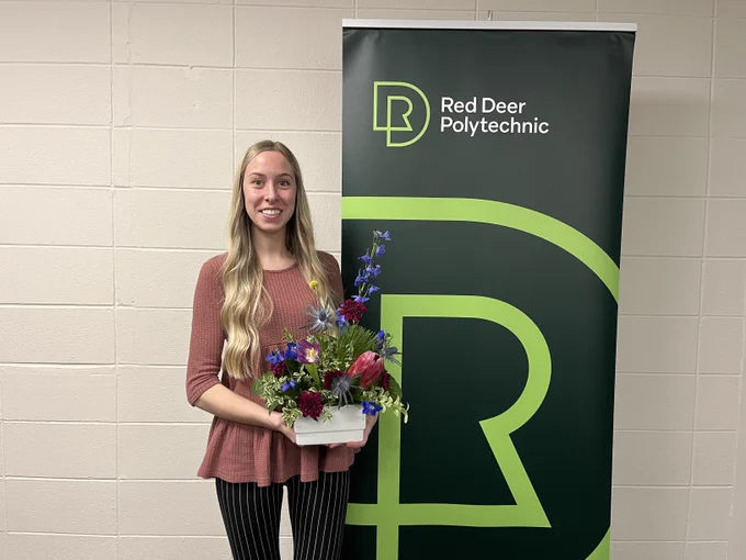 A photo of Tamara holding her Celebrate & Empower arrangement. Both Tamara and STEMS owner, Amanda, are RDP alumni!