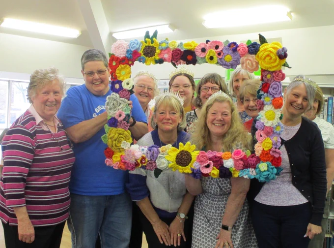 group or women holding fram made from knitted flowers