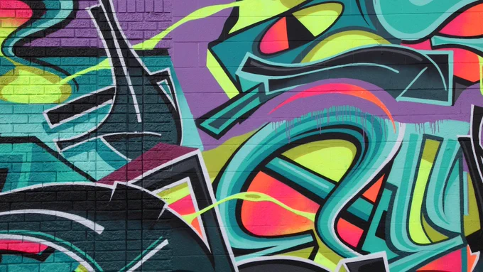 A brick wall with colourful graffiti.