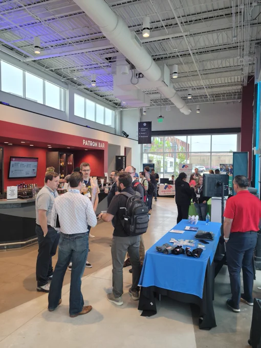  Attendees of DevOpsDays Birmingham standing and conversing outside in a hall.