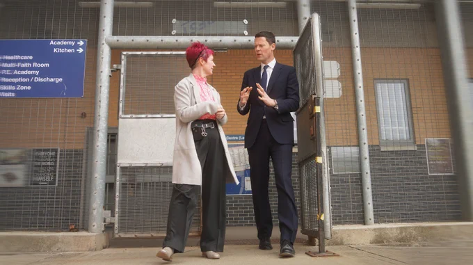 Lord Chancellor and HMP Isis governor Emily Thomas walking through a gate at the prison.