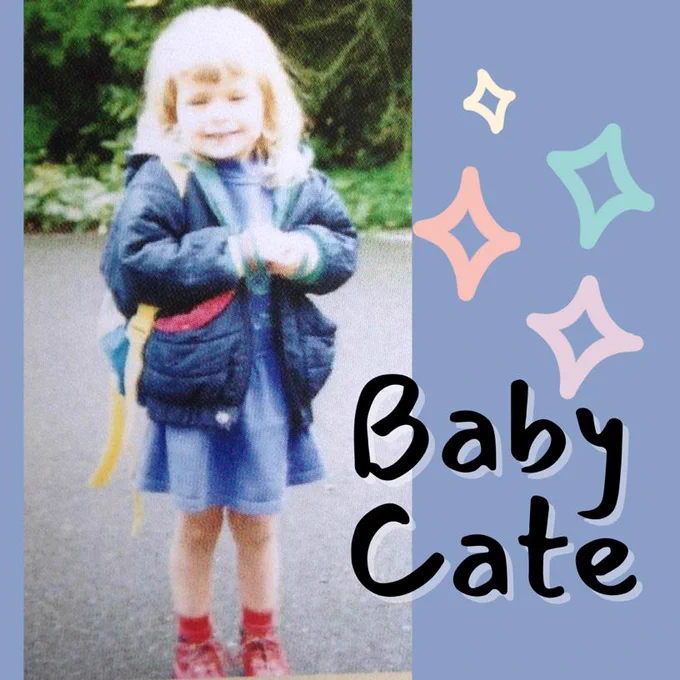 Image is a photo of Cate on her first day of school. She is wearing a very 90s navy puffer coat, a blue dress, a backpack, and bright read shoes. Text reads: baby Cate.