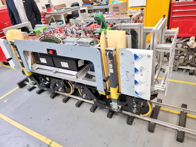 minature test train semi-built on a short section of track within a workshop. 