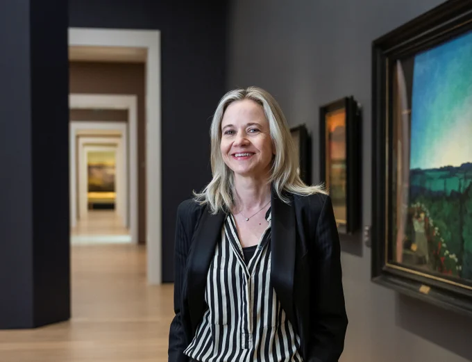 Portrait of a woman smiling inside a gallery