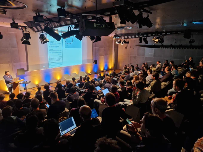 Photography of the auditorium in which Piyush Jain is introducing the talk about Jupyter AI.