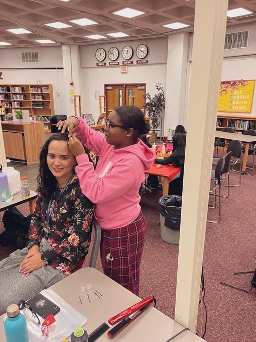 Cosmetology student doing braids for a happy teacher