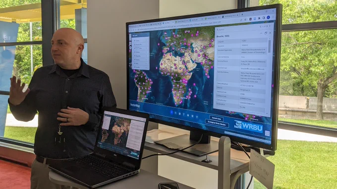 David Pecor giving a demostration of VectorMap using a computer and a large screen with a map of the world. See https://vectormap.si.edu/