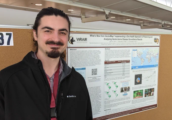 Alex Potter stands in front of a poster describing the new and improved VectorMap