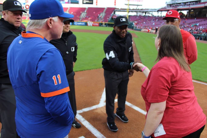 Stephanie Herber meets with coaches from both team and the umpiring crew of the 5/10/23 match-up between the Cincinnati Reds and the New York Mets. Stephanie served as Honorary Captain prior to the game.