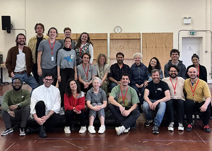 The Falkland Sound company in a rehearsal room, standing behind and sitting in front. 