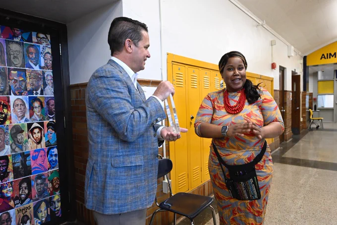 Tierra Ross smiles while Dr. Marty Pollio holds her Lighthouse Award.