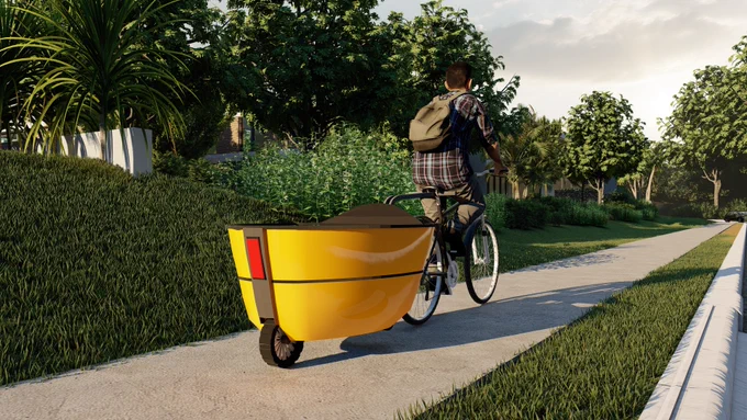 A design drawing of the electric trailer. A person is cycling with the stylish yellow trailer attached to the back of the bike. They are on concrete and surrounded by trees and grass.
