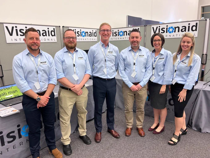Team photo in front of the VisionAid Internation stand , from left to right - Ben, Jonathan, Ellis, Jason, Kate and Kat.
