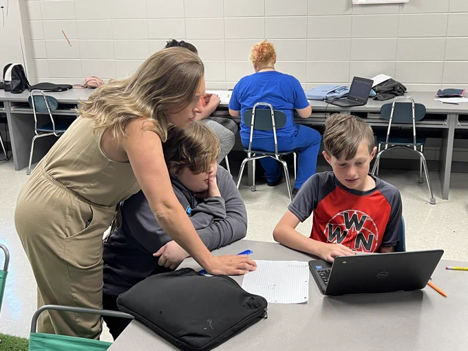 KY ILN Innovative Teacher Meagan Ralph consults with students on an assignment where they are mapping their school and other schools in the district using Google Earth, poster materials, etc.