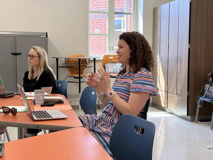 KY ILN Innovative Teacher Kalli Colley offers feedback to a student after a defense of learning. A colleague listens and prepares to give feedback at her side.
