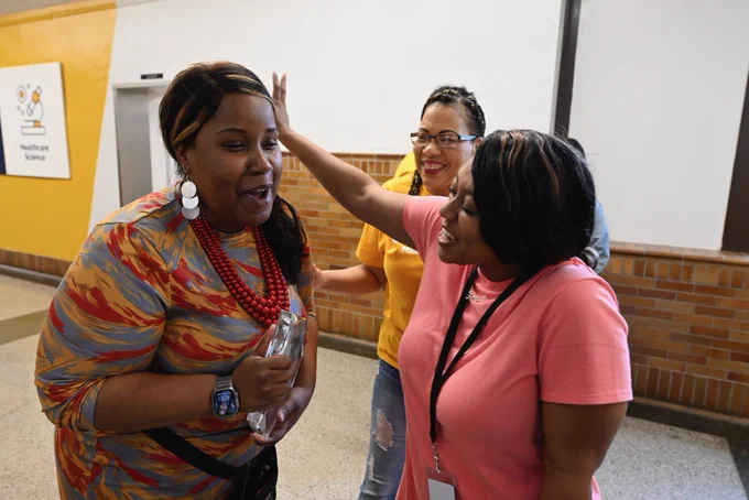 Tierra Ross holds her Lighthouse Leader award and smiles with co-workers.