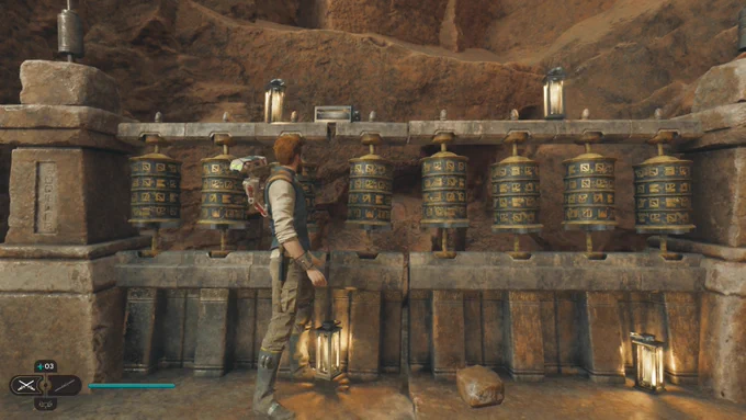 Cal Kestis stands in front of 8 vertical metal Prayer Wheels marked all around with Domabesh runes.