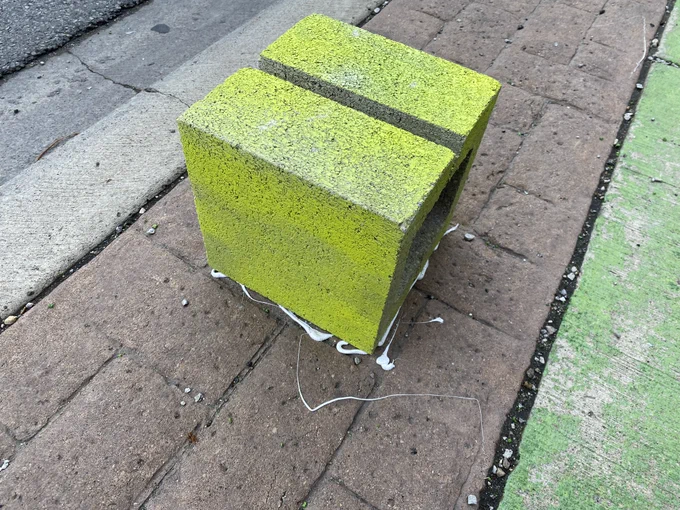 closeup of cement block spray-painted neon yellow